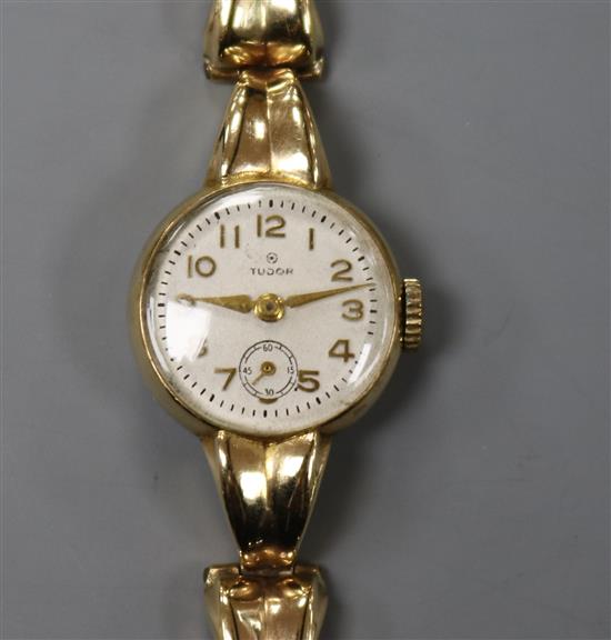 A ladys 9ct gold Tudor manual wind wrist watch, on a 9ct gold bracelet.